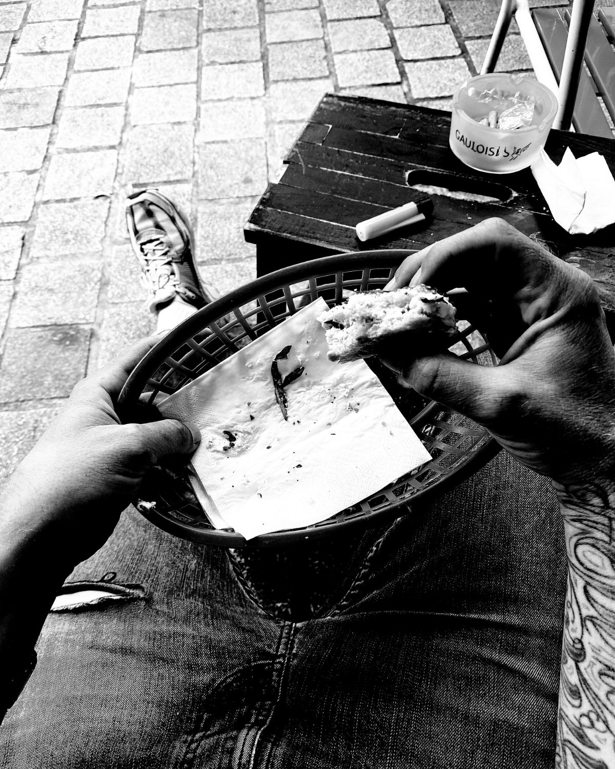 Hands holding food at an outdoor table