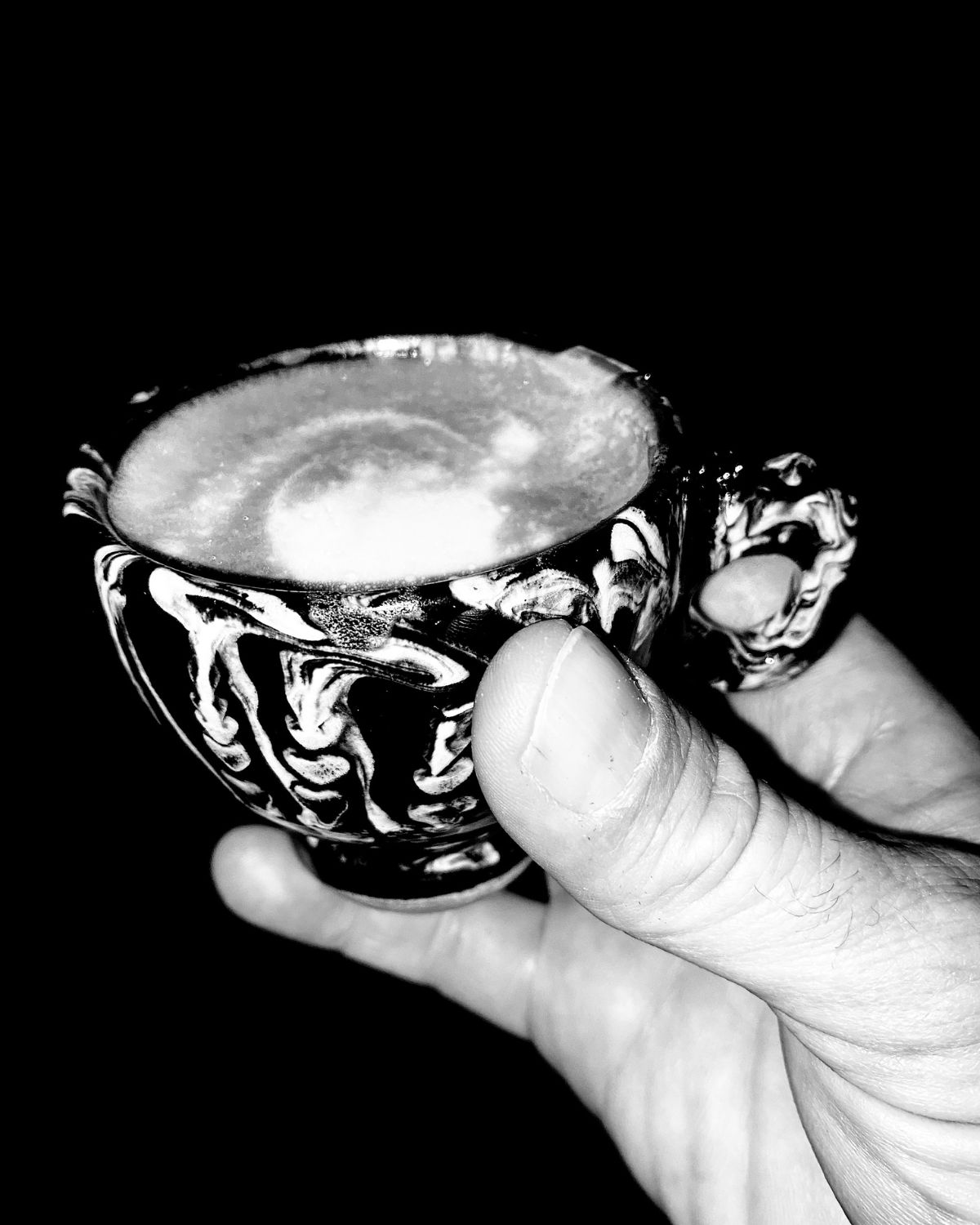 Ornate coffee cup held in a hand