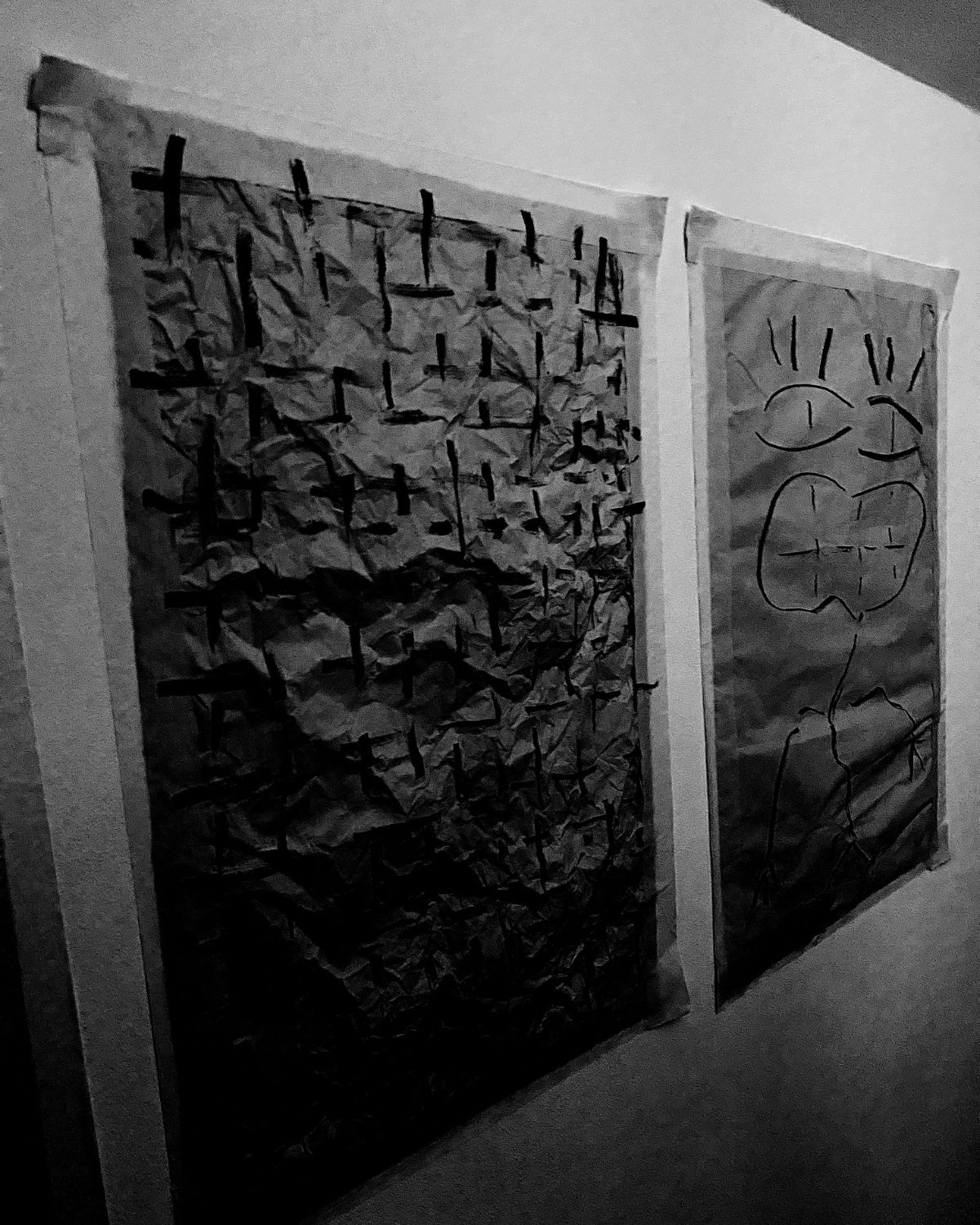 Two textured artworks hanging on a wall